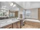 Bright bathroom with double sinks, a large mirror, walk-in shower, and separate soaking tub at 2154 Tortona St, Henderson, NV 89044