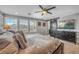 Bright bedroom with a large bed, ceiling fan, dark wood dresser and sliding barn door at 2154 Tortona St, Henderson, NV 89044
