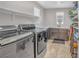 Convenient laundry room with modern washer and dryer, utility sink, storage cabinets and shelves at 2154 Tortona St, Henderson, NV 89044