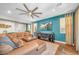 Cozy living room featuring a comfortable sectional sofa, a large ceiling fan, and a modern entertainment center at 2154 Tortona St, Henderson, NV 89044