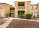 An exterior view of a condo building with landscaping, access ramps and stairs at 2300 E Silverado Ranch Blvd # 1070, Las Vegas, NV 89183