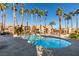 Beautiful community pool surrounded by tall palm trees, lounge chairs, and well-maintained landscaping at 2300 E Silverado Ranch Blvd # 1070, Las Vegas, NV 89183