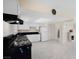 Well-lit kitchen boasts white cabinetry, a black range, and modern appliances adjacent to the living area at 2375 Marion St, Las Vegas, NV 89104