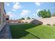 This backyard features a grass lawn, fire pit, block wall, and space for outdoor activities at 258 Chamomile Dr, Henderson, NV 89015