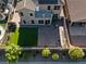 Aerial view of a backyard featuring a patio, artificial grass, seating area, and a fire pit with desert landscaping at 258 Chamomile Dr, Henderson, NV 89015