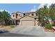 A well-maintained two-story home with a three car garage and desert landscaping under a sunny blue sky at 258 Chamomile Dr, Henderson, NV 89015