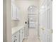 A hallway view leading into a kitchen with white cabinets and stainless appliances at 258 Chamomile Dr, Henderson, NV 89015