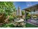 Charming backyard featuring a shaded patio area, lush greenery, and a stylish outdoor seating arrangement at 3048 Scalise Ct, Las Vegas, NV 89141