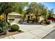 Charming home featuring mature trees, manicured bushes, and a spacious two-car garage at 3048 Scalise Ct, Las Vegas, NV 89141