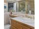 The primary bathroom features a large mirror, glass shower, wood cabinets and tile counters at 3233 Southridge Ave, Las Vegas, NV 89121