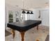 A home game room features a covered pool table with light fixture, and views to the outside at 3233 Southridge Ave, Las Vegas, NV 89121