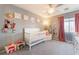 Bright Bedroom with a white crib, pink curtains and creative decor, creating a cozy and inviting space at 3309 Green Ice Ave, North Las Vegas, NV 89081