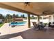 Covered patio area with outdoor seating overlooking the backyard pool and landscaping at 3309 Green Ice Ave, North Las Vegas, NV 89081