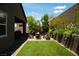 Exterior shot of backyard featuring a covered patio, dining area, fire pit lounge and artificial turf at 3395 Sleeping Hills Ave, Henderson, NV 89044