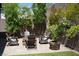Inviting backyard patio featuring brick pavers, seating around a modern fire pit and lush landscaping at 3395 Sleeping Hills Ave, Henderson, NV 89044