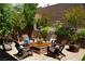 Inviting backyard patio featuring brick pavers, seating around a modern fire pit and lush landscaping at 3395 Sleeping Hills Ave, Henderson, NV 89044