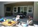 Stylish covered patio with brick pavers, an outdoor dining area and a fire pit lounge with Adirondack chairs at 3395 Sleeping Hills Ave, Henderson, NV 89044