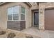 Inviting entryway with a brick accent wall, modern windows and a tiled walkway at 3395 Sleeping Hills Ave, Henderson, NV 89044