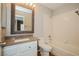 Bathroom with granite vanity, decorative mirror, and combination tub and shower at 3416 Steppe St, North Las Vegas, NV 89032