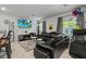 Stylish living room featuring a comfortable black leather sectional sofa and ample natural light from large windows at 3517 Arcadian King Ave, Las Vegas, NV 89106