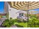 Outdoor patio area featuring grill, umbrella, lush landscaping, and comfortable dining space at 4145 Nopal Serrano Ave, Las Vegas, NV 89141