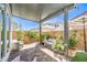 Inviting covered patio area with comfortable seating, stylish umbrella, and beautiful brick flooring at 4145 Nopal Serrano Ave, Las Vegas, NV 89141