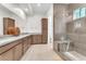Modern bathroom featuring dual sinks, a spacious walk-in shower, and warm, neutral tones throughout at 4153 Solace St, Las Vegas, NV 89135