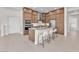 Kitchen featuring brown cabinetry, stainless appliances, breakfast bar, and kitchen island with sink at 4153 Solace St, Las Vegas, NV 89135