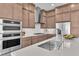 Gourmet kitchen featuring stainless steel appliances, stone countertops, and custom cabinets at 4153 Solace St, Las Vegas, NV 89135