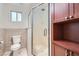 This bathroom features a glass enclosed shower, ceramic tile floor, toilet, window, and built in storage cabinet at 4302 Newhaven Dr, Las Vegas, NV 89147