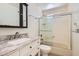 Bright bathroom with a marble countertop vanity, dark wood medicine cabinet, and shower over tub with sliding glass doors at 4302 Newhaven Dr, Las Vegas, NV 89147