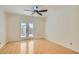 This bedroom features light hardwood floors, a ceiling fan, french doors with access to the balcony at 4302 Newhaven Dr, Las Vegas, NV 89147