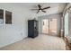 Bright sunroom featuring tile flooring, sliding glass doors, a ceiling fan and black refrigerator at 4302 Newhaven Dr, Las Vegas, NV 89147