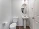 Well-lit powder room with modern fixtures, pedestal sink and wood-look flooring at 4650 Ranch House Rd # 86, North Las Vegas, NV 89031