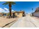 This home offers desert landscaping with mature palm tree, long driveway and covered front porch at 513 Berry Cir, Las Vegas, NV 89107