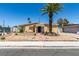 Charming single-story home featuring desert landscaping, a front yard palm tree, and a covered front porch at 513 Berry Cir, Las Vegas, NV 89107