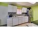 Kitchen with white cabinetry, stainless steel appliances, and a mosaic tile backsplash at 513 Berry Cir, Las Vegas, NV 89107