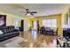 Bright living room with wood-look laminate flooring, ceiling fan, and a large front-facing window at 513 Berry Cir, Las Vegas, NV 89107