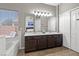 Bathroom with double sink vanity and large mirror illuminated by modern vanity lighting at 5421 Tourmaline St, Las Vegas, NV 89130