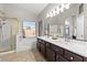 Bright bathroom featuring double vanity, shower with gold frame, and large window at 5421 Tourmaline St, Las Vegas, NV 89130