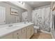 Bathroom features a double sink vanity with granite countertop, a large mirror, and a shower-tub combo at 5421 Tourmaline St, Las Vegas, NV 89130