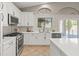 Bright modern kitchen with white cabinets, quartz countertops, stainless steel appliances, and tile floors at 5421 Tourmaline St, Las Vegas, NV 89130