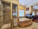 Elegant bathroom features a soaking tub with fireplace, walk-in shower, and double vanity at 5445 Pendini Point Ct, Las Vegas, NV 89141