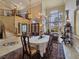 Elegant dining area with large windows, a view into the formal living room, and an ornate chandelier at 5445 Pendini Point Ct, Las Vegas, NV 89141