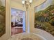 Elegant foyer showcasing detailed tile work, decorative chandelier, and beautiful wall murals at 5445 Pendini Point Ct, Las Vegas, NV 89141