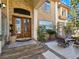Elegant entryway showcasing stone accents, a detailed wooden double door, and outdoor seating area at 5445 Pendini Point Ct, Las Vegas, NV 89141