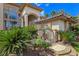 Well-manicured front yard with mature landscaping and secure gated entrance to the luxury home at 5445 Pendini Point Ct, Las Vegas, NV 89141
