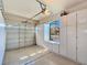 Organized two-car garage with storage cabinets, window, and automatic door enhancing functionality and appeal at 5445 Pendini Point Ct, Las Vegas, NV 89141