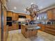Spacious kitchen with island, hanging pot rack, and tiled flooring at 5445 Pendini Point Ct, Las Vegas, NV 89141