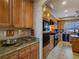 Traditional kitchen with wooden cabinets, granite counters, and black appliances at 5445 Pendini Point Ct, Las Vegas, NV 89141